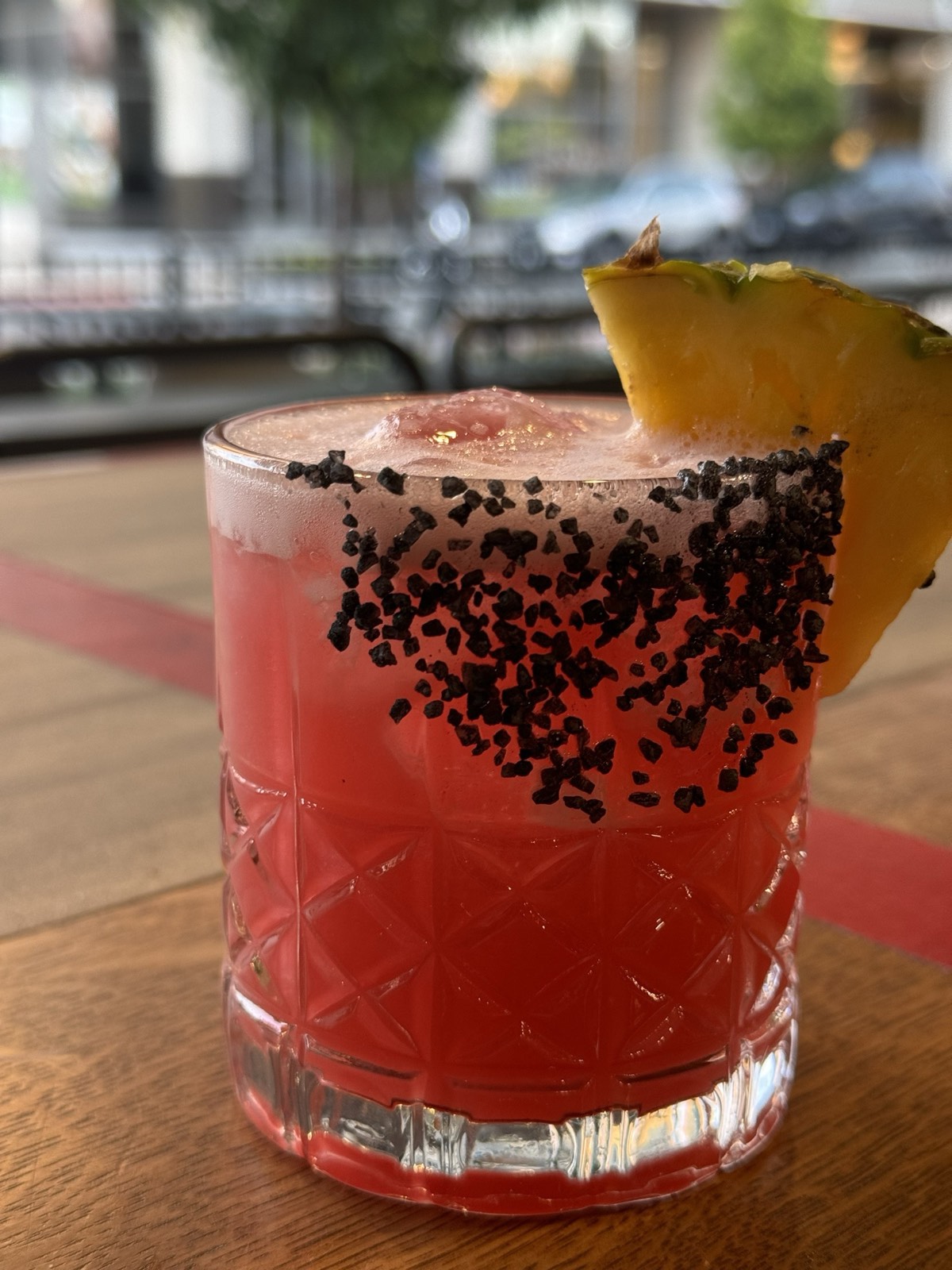 A signature cocktail with a black salt rim